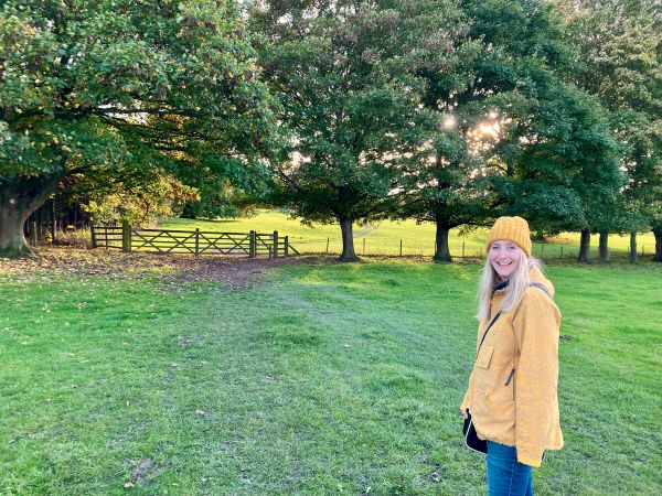 Johanna Elvidge in yellow hat + coat in rural landscape at National Trust Nostell Priory