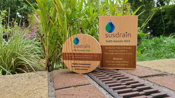 two CIRIA susdrain SuDS award trophies, on channel and next to pond