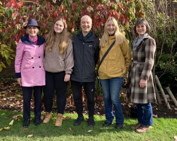 The 2B team of 5 in a group in front of a shrub border